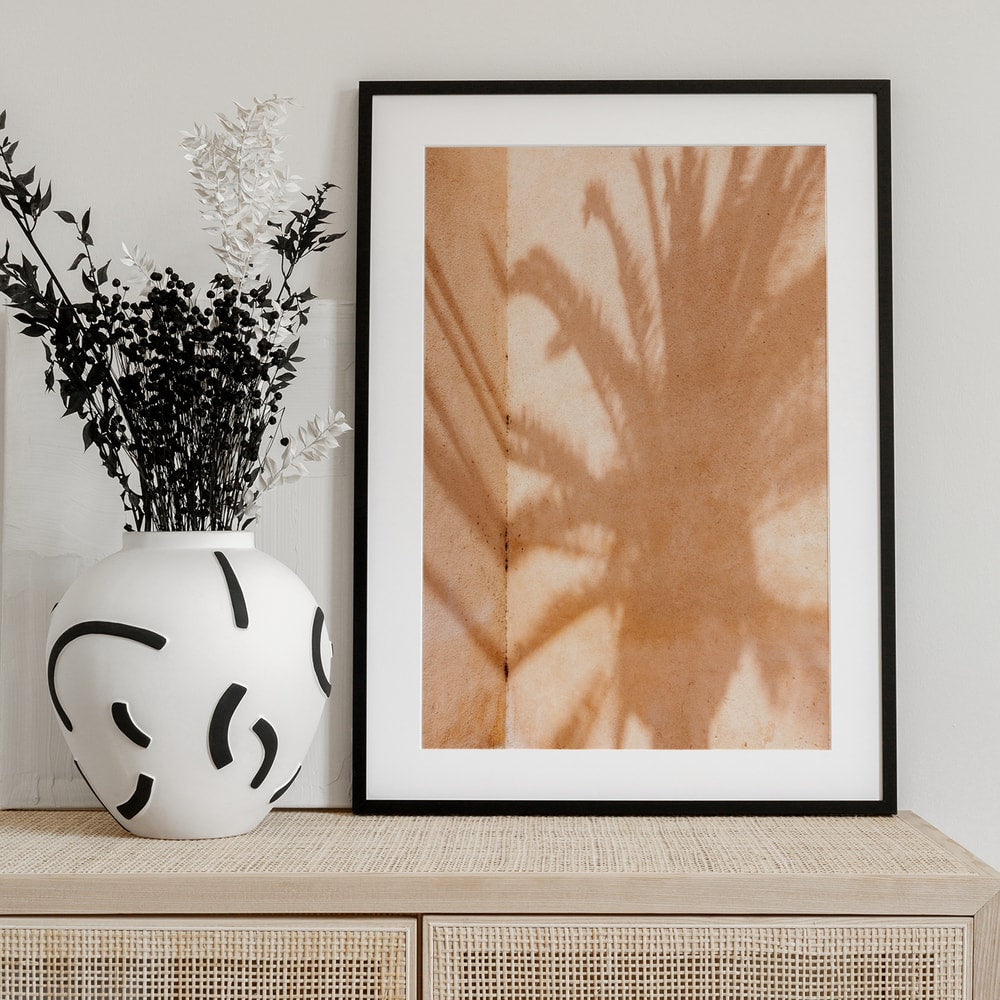 Fotografie eines Palmenschattens auf einer sandfarbenen Wand