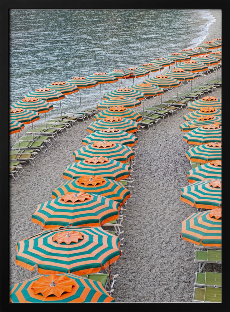 Luftaufnahme geschwungener Reihen orange-türkiser Sonnenschirme an einem Kiesstrand