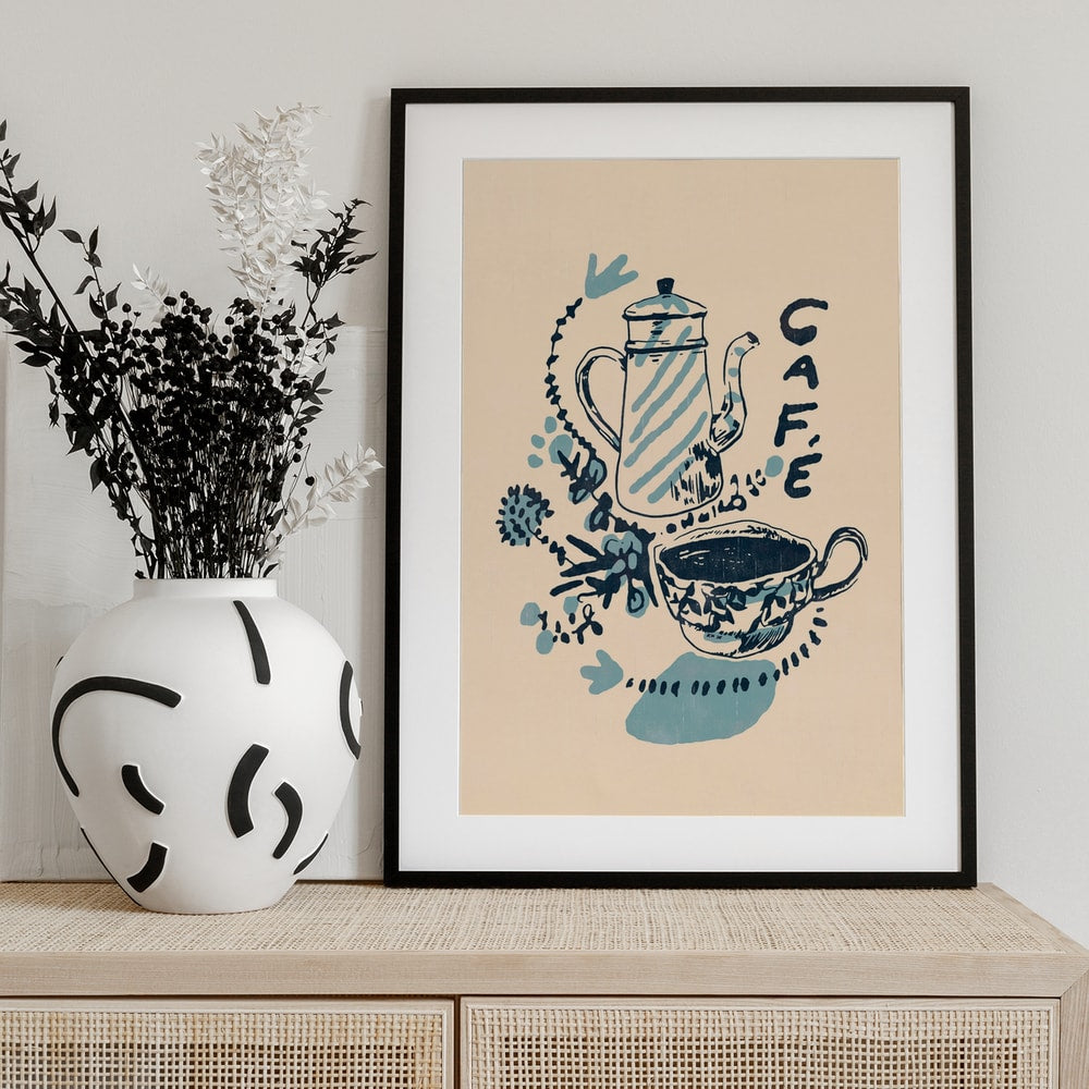 Handgezeichnete Kaffeekanne und Tasse in Blau auf cremefarbenem Hintergrund mit Schriftzug Café