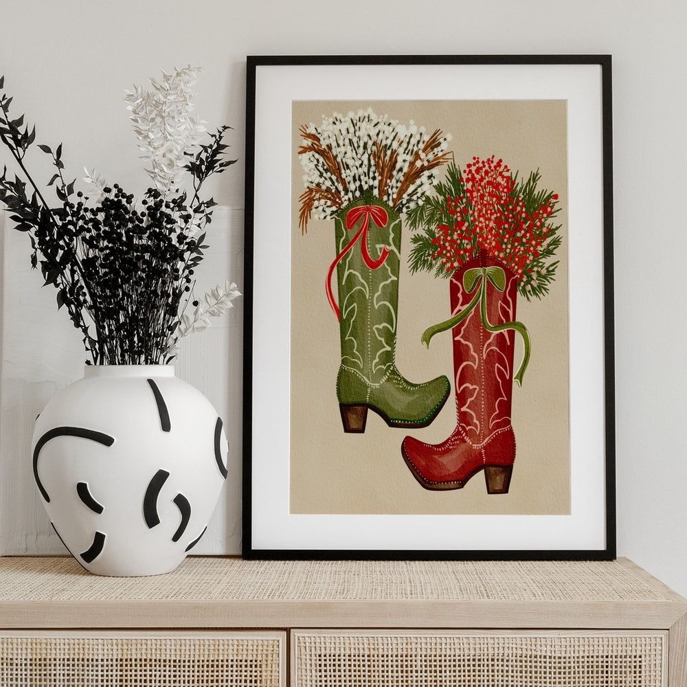 Illustration eines grünen und eines roten Cowboystiefels mit Beeren, Zweigen und Schleifen