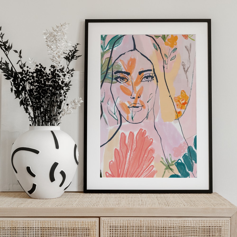 Linienzeichnung eines Frauengesichts zwischen rosa, orangen und grünen Blüten