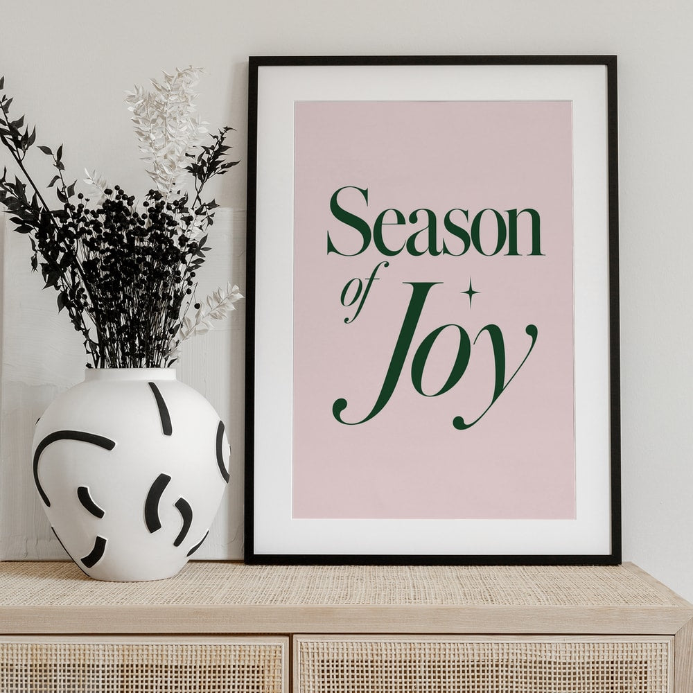 Typografie-Motiv mit dem Schriftzug Season of Joy in Dunkelgrün auf rosa Hintergrund