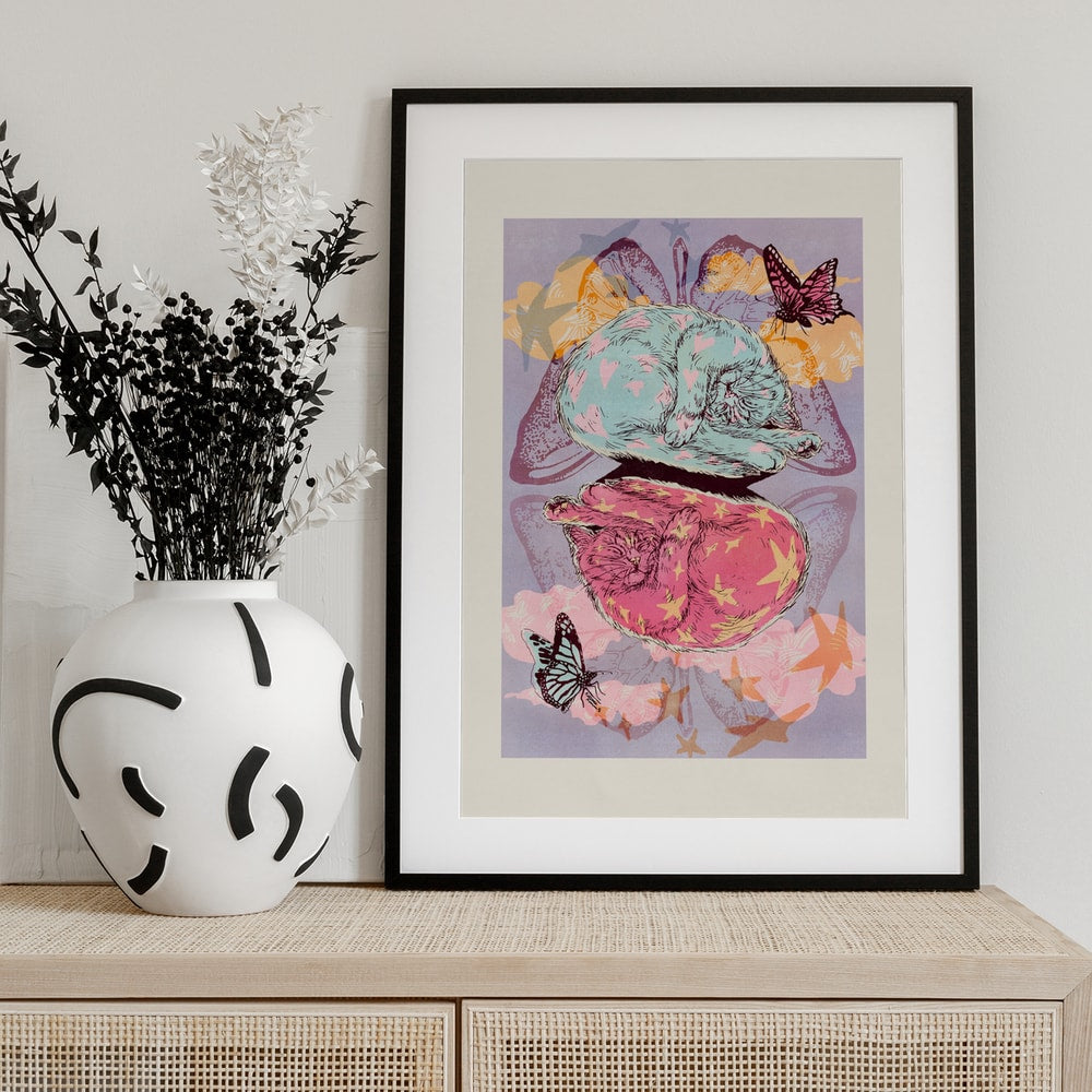 Illustration zweier schlafender Katzen in Mint und Pink mit Schmetterlingen und Sternen