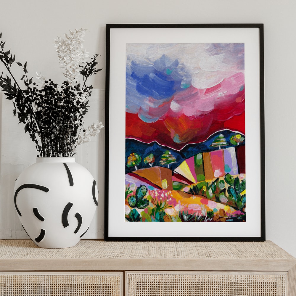 Expressives Gemälde einer bunten Wüstenlandschaft mit Kakteen und wolkigem Himmel