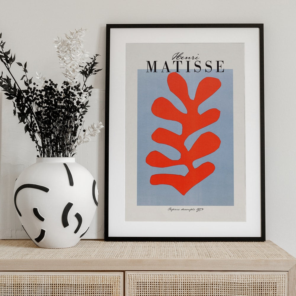 Ausstellungsplakat Henri Matisse mit korallenrotem Scherenschnitt-Blatt auf hellblauem Grund, schwarzer Schriftzug