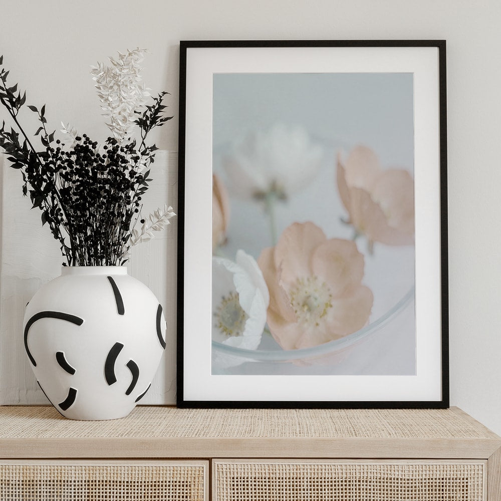 Fotografie zarter cremefarbener und pfirsichfarbener Blüten in einer Glasschale