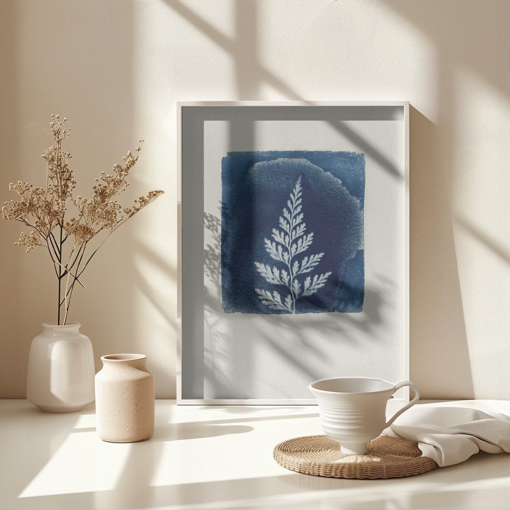 Weißes Farnblatt auf blauem Quadrat im Cyanotypie-Stil auf hellem Papier