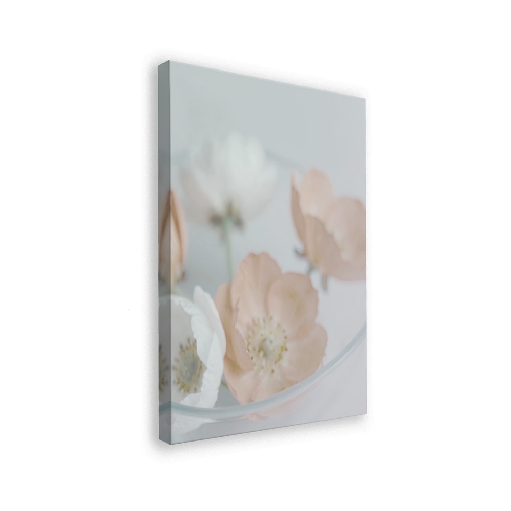 Fotografie zarter cremefarbener und pfirsichfarbener Blüten in einer Glasschale