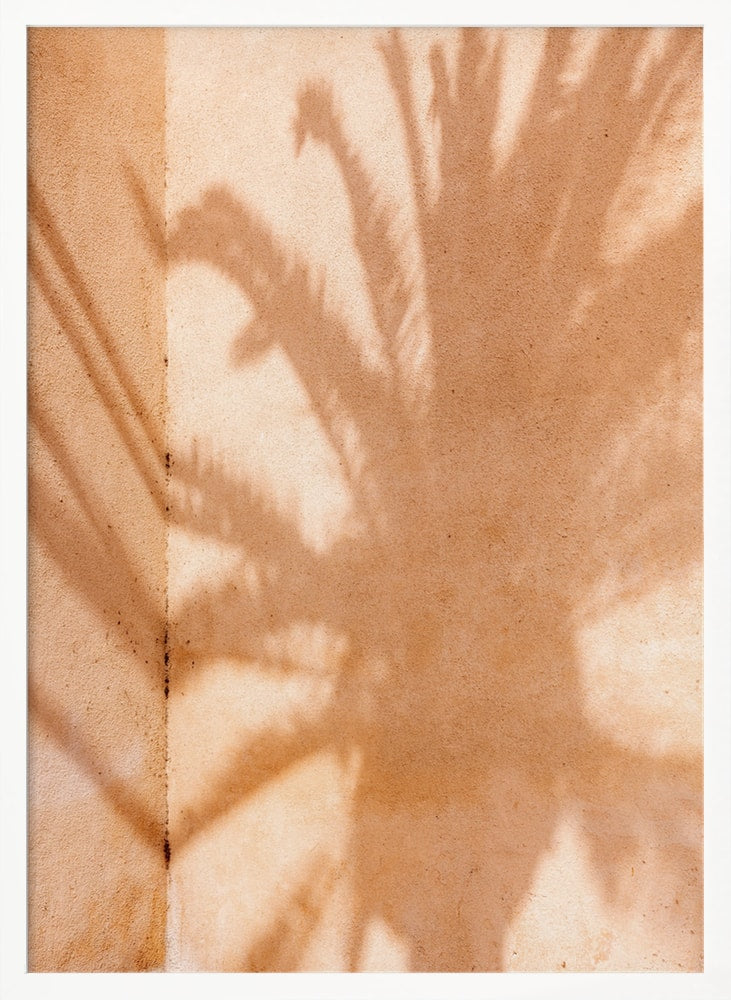 Fotografie eines Palmenschattens auf einer sandfarbenen Wand