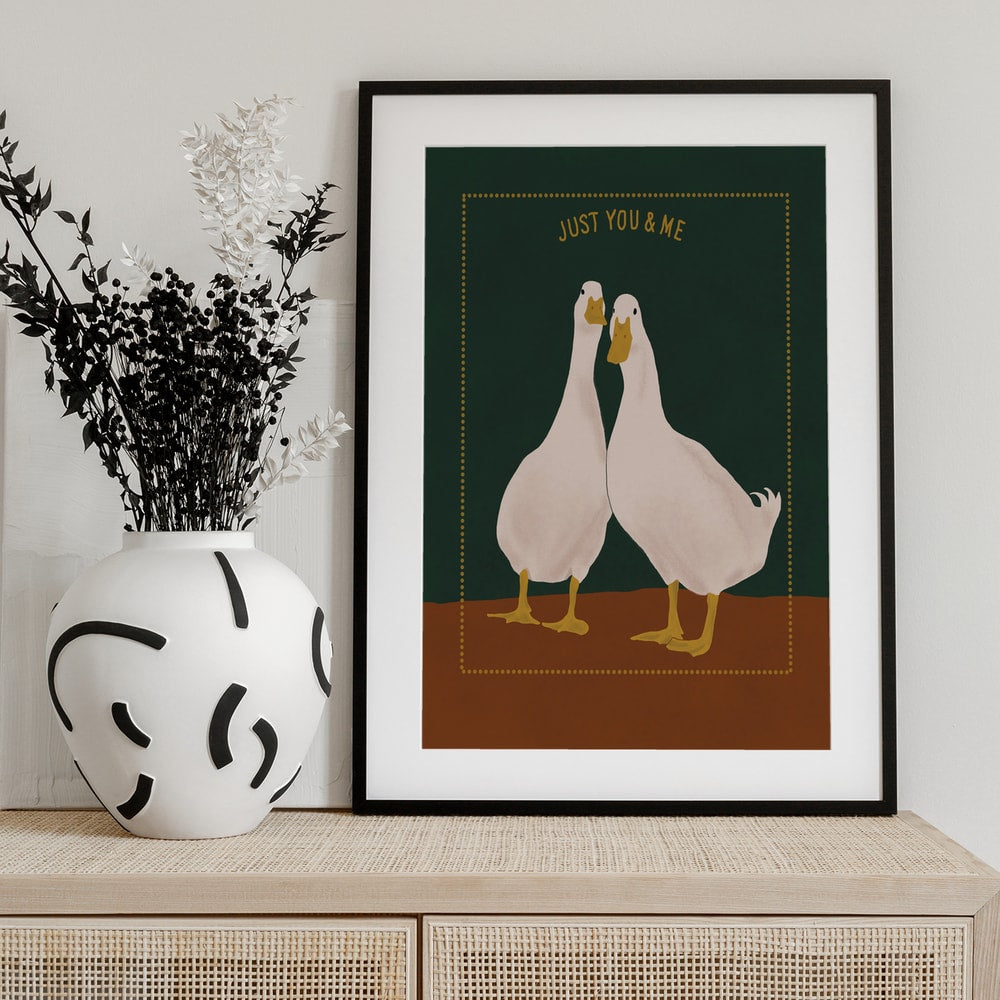 Zwei weiße Enten nebeneinander auf grünem Hintergrund mit Schriftzug Just You & Me