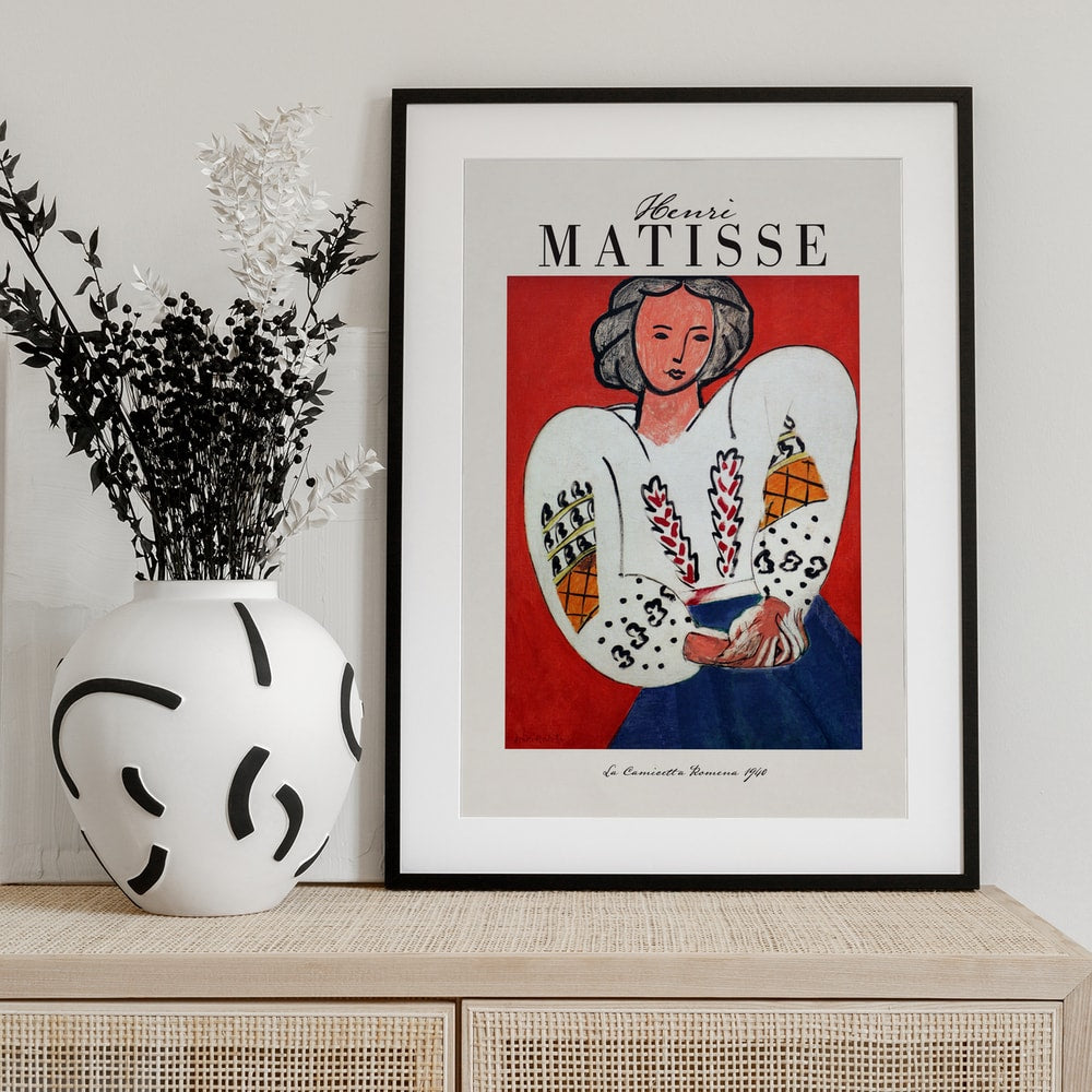 Ausstellungsplakat Henri Matisse mit Frau in bestickter weißer Bluse vor rotem Hintergrund