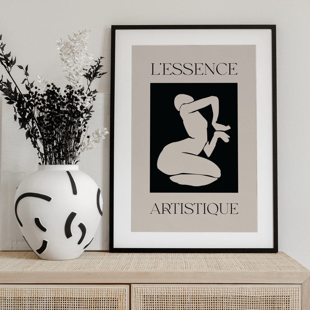 Helle kniende Figur im Scherenschnitt-Stil auf schwarzem Feld mit Schriftzug L'Essence Artistique