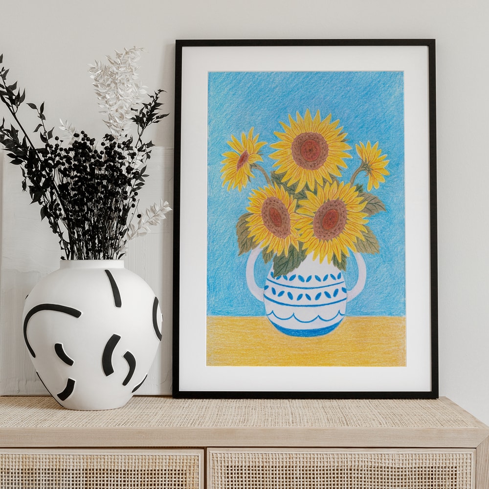 Buntstiftzeichnung von Sonnenblumen in blau-weißem Krug vor hellblauem Hintergrund