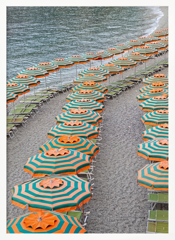 Luftaufnahme geschwungener Reihen orange-türkiser Sonnenschirme an einem Kiesstrand