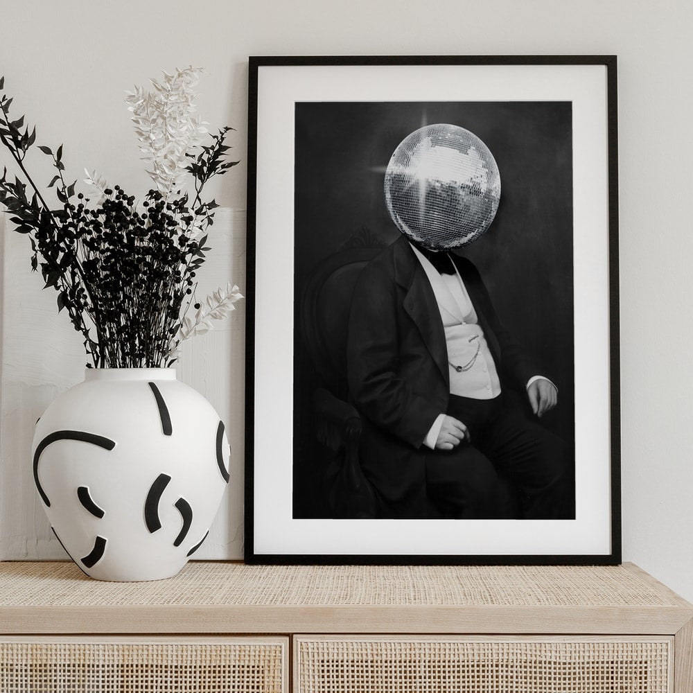 Schwarz-weißes Vintage-Porträt eines sitzenden Herrn im Frack mit Discokugel statt Kopf