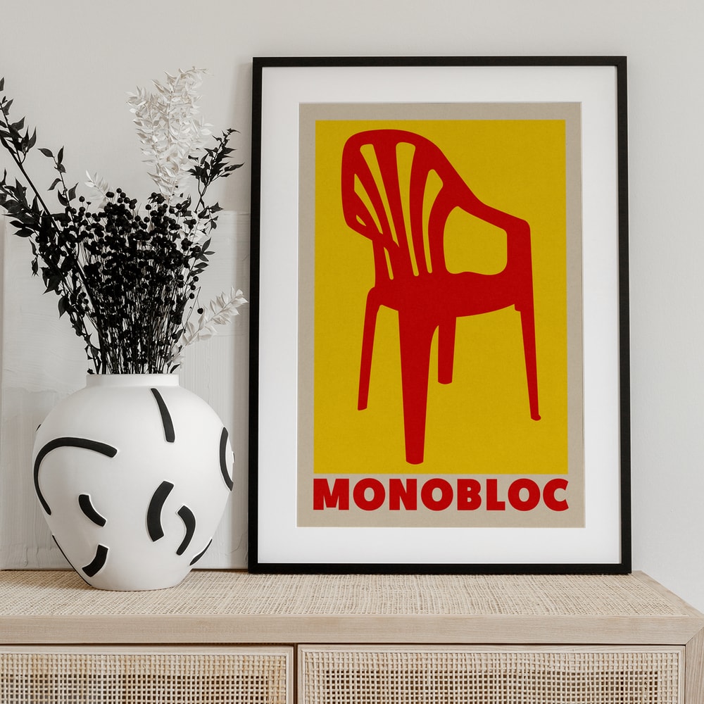 Grafische Illustration eines roten Monobloc-Stuhls vor gelbem Hintergrund mit Schriftzug Monobloc