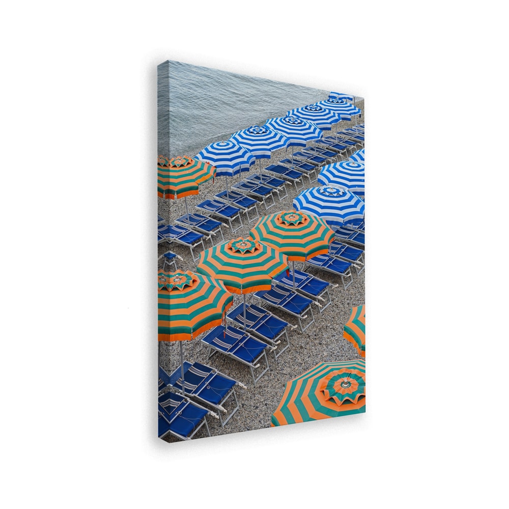 Luftaufnahme von Reihen blau-weißer und orange-grüner Sonnenschirme mit blauen Liegen