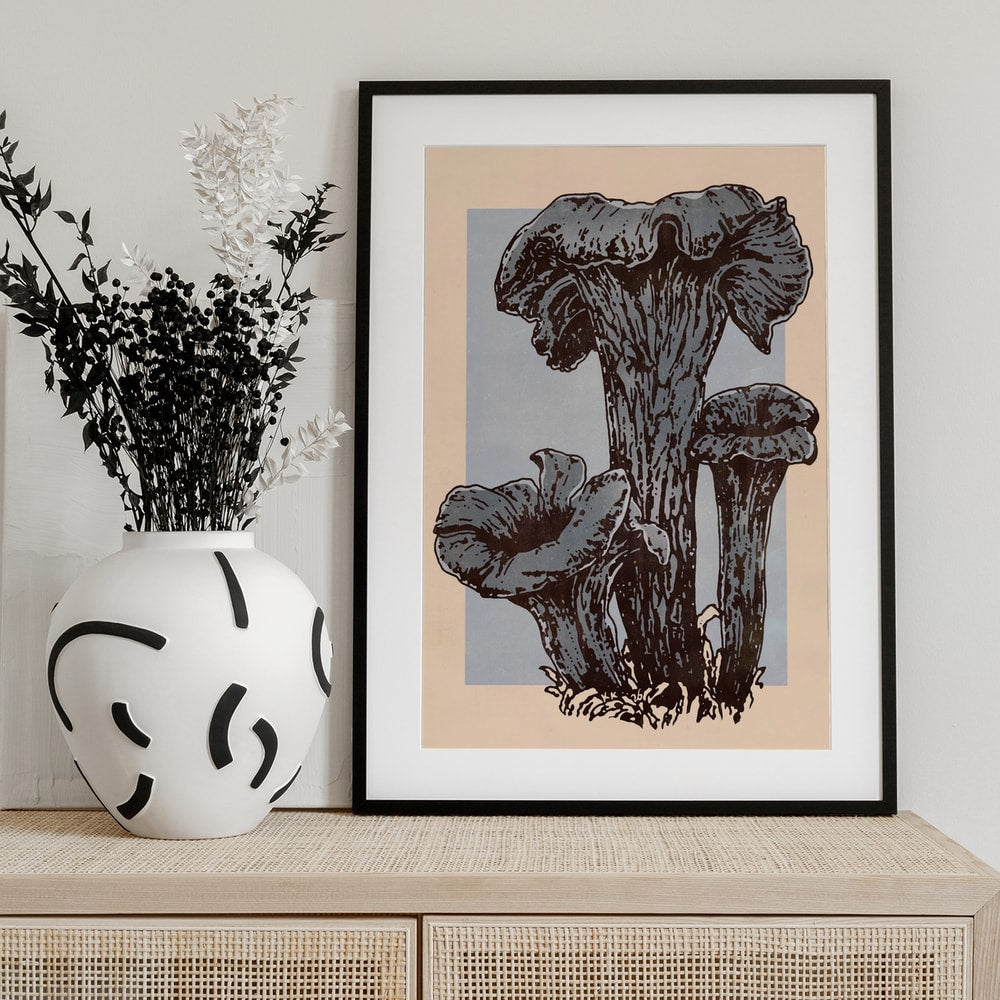 Illustration von drei dunklen Herbsttrompeten-Pilzen auf grauem und pfirsichfarbenem Hintergrund